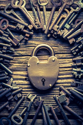 Vintage keys and locks on old wooden table